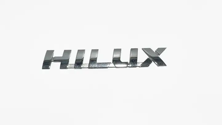 Toyota Hilux (AN10, AN20, AN30) (2011 - 2015) 754270K030 Эмблема модели — фото 1