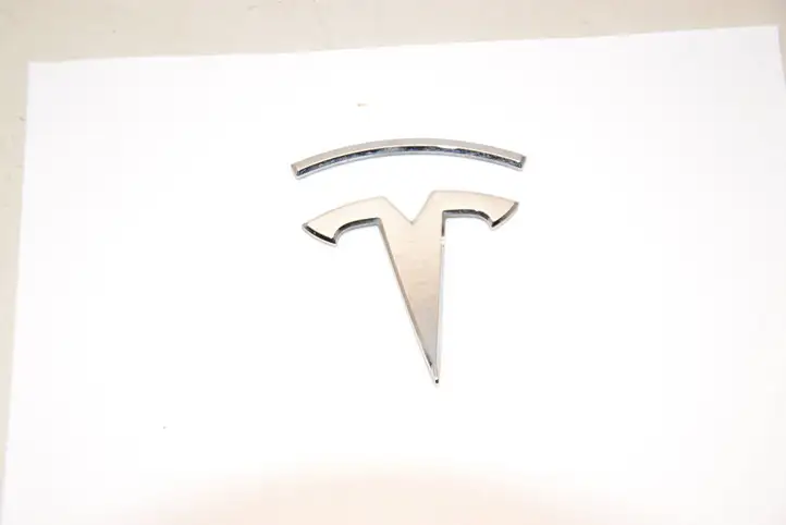 Tesla Model X (2015 - 2021) 104785400A Эмблема автомобиля — фото 1