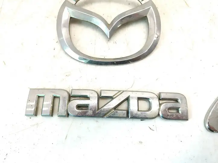 Mazda 6 (2002 - 2005) Эмблема производителя — фото 7